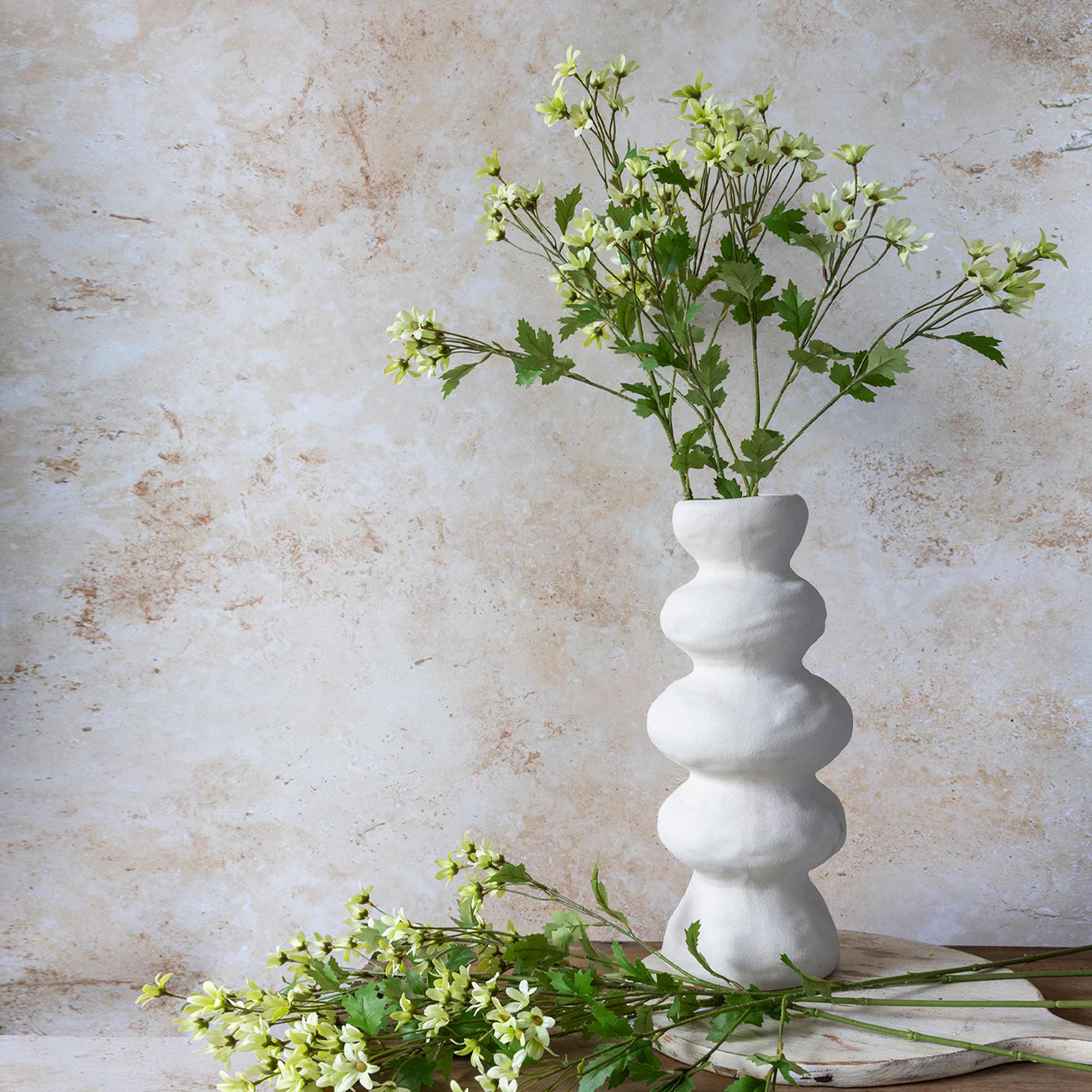 Artificial daisies with relaxed branching and soft cream petals
