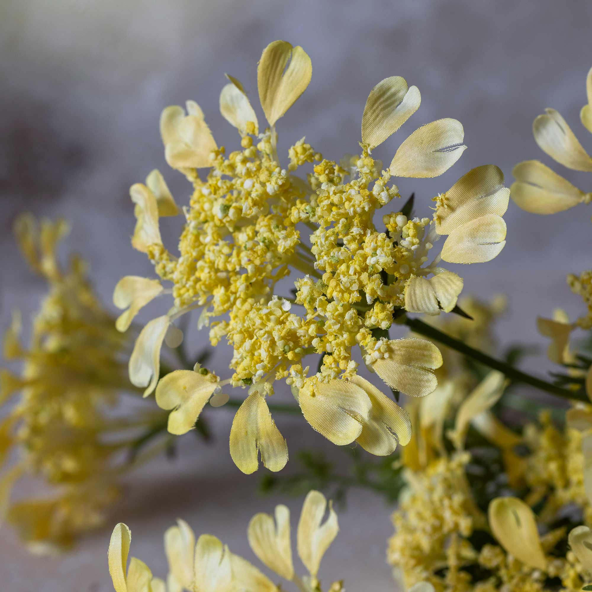 Artificial yellow flowers with flat-topped blooms and fine foliage
