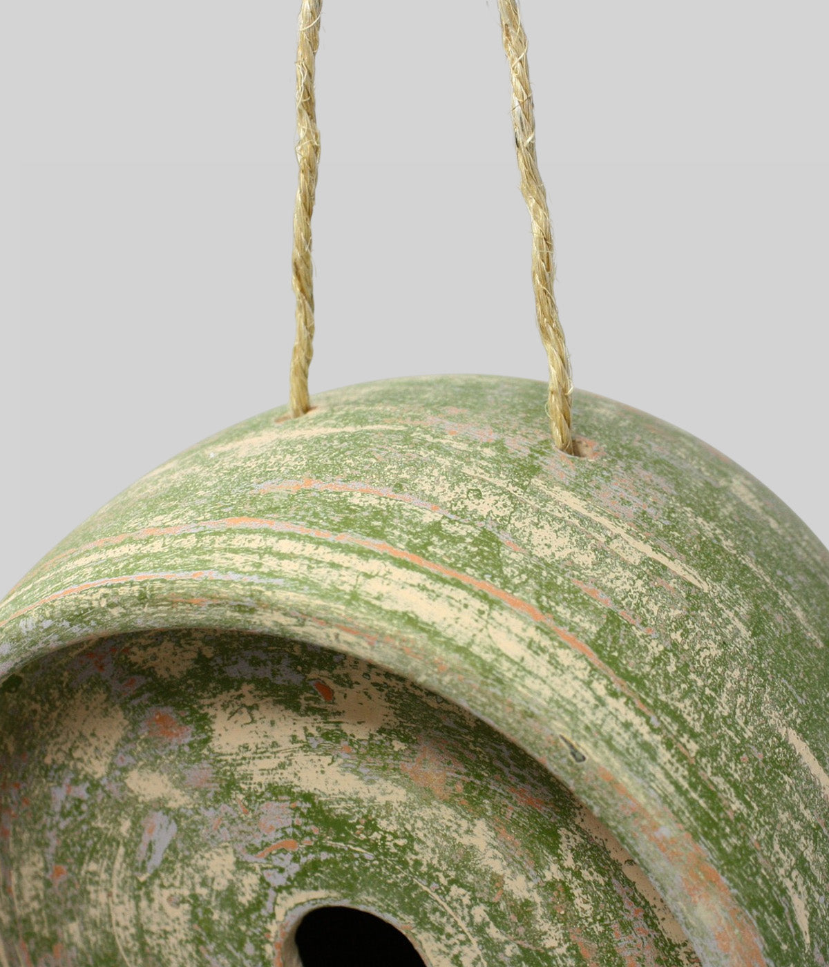 Close-up of the Garden Sage terracotta birdhouse showing jute rope suspension threaded through the top and its textured sage finish