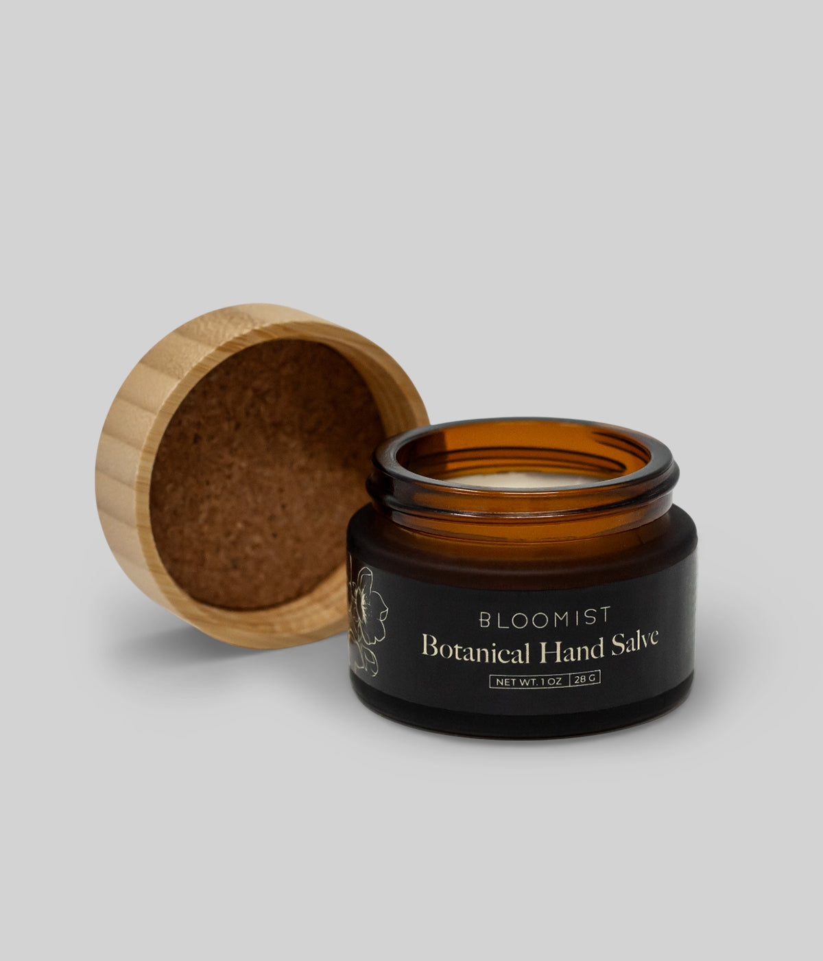 Open jar of botanical salve for skin with wooden lid beside it