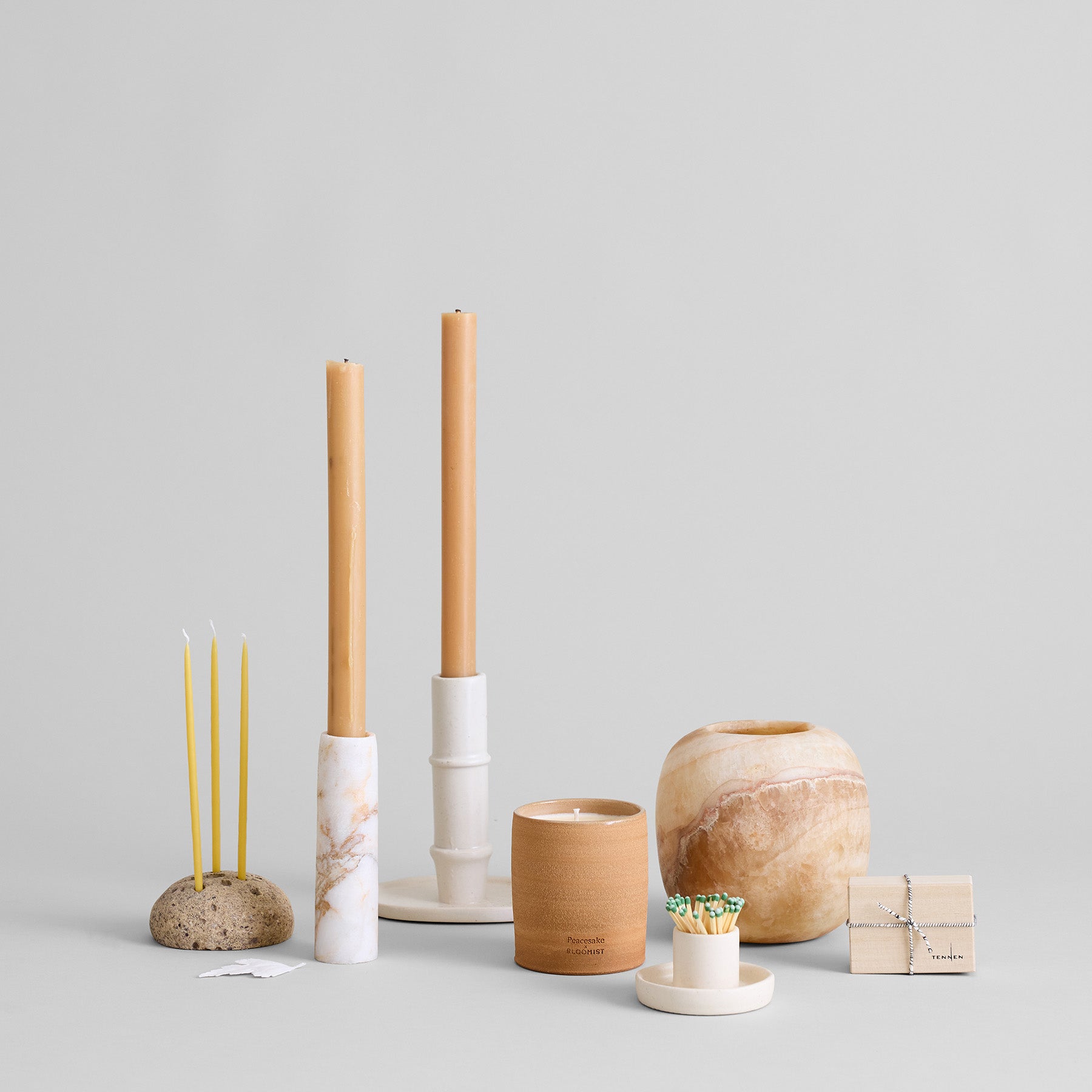 Stone flower frog styled alongside candles and wooden objects