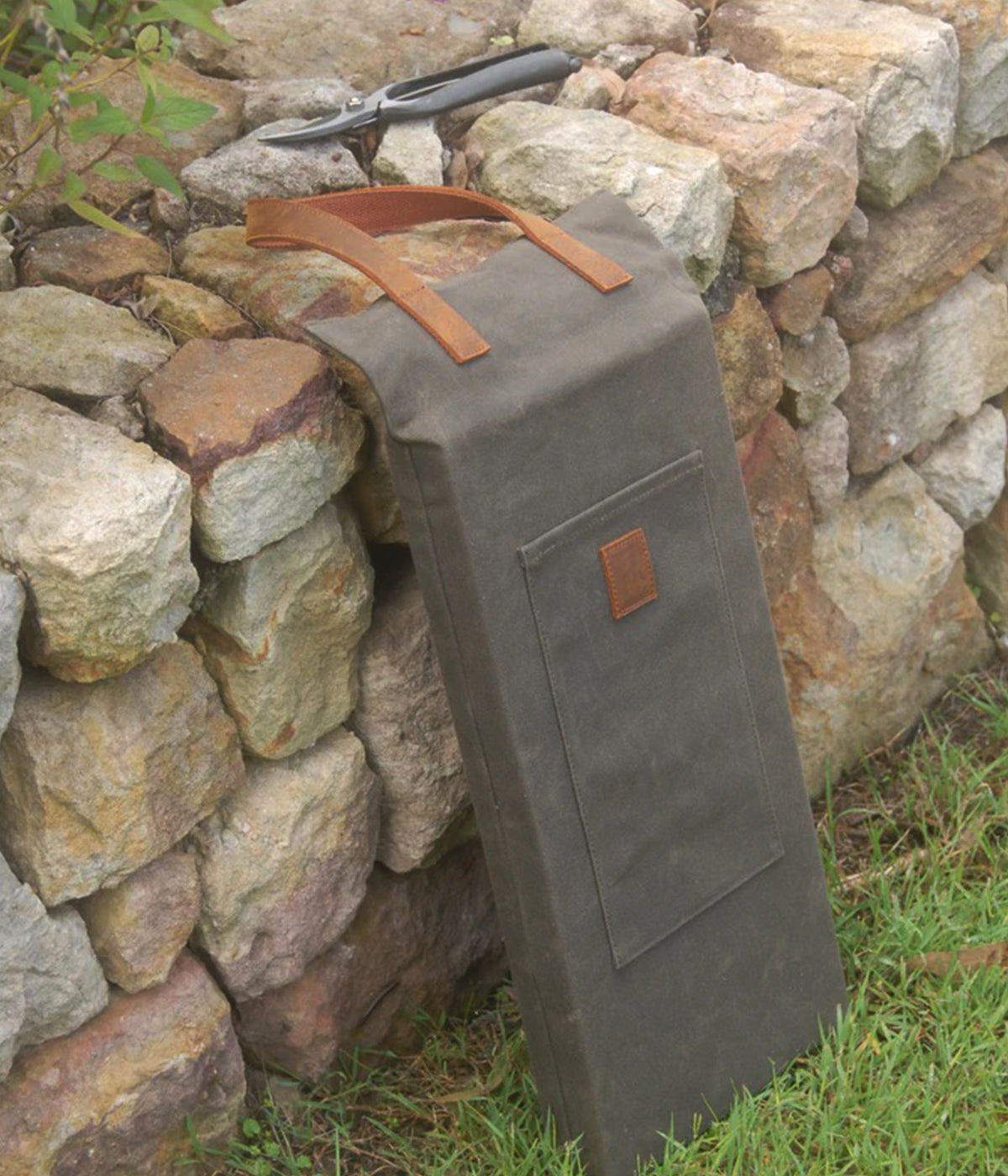 Gardening knee pad with front pocket and stitched leather handle