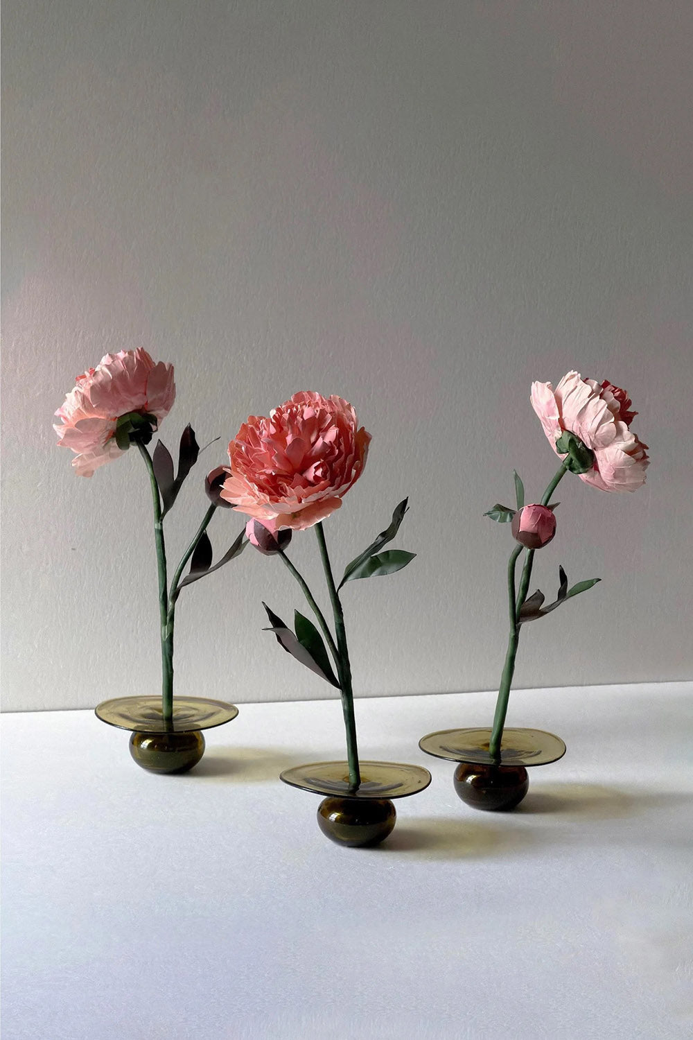 Three beeswax paper Chinese peony flowers displayed together in glass bases