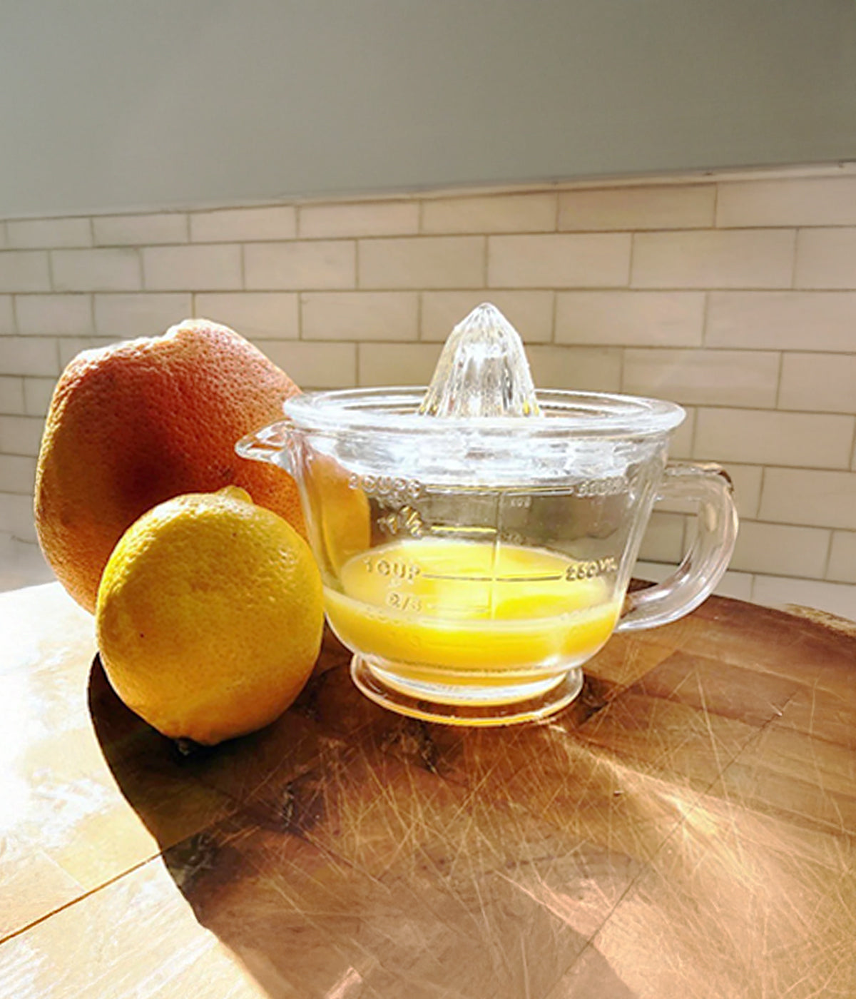 Clear glass citrus juicer made with ounce and cup measurements