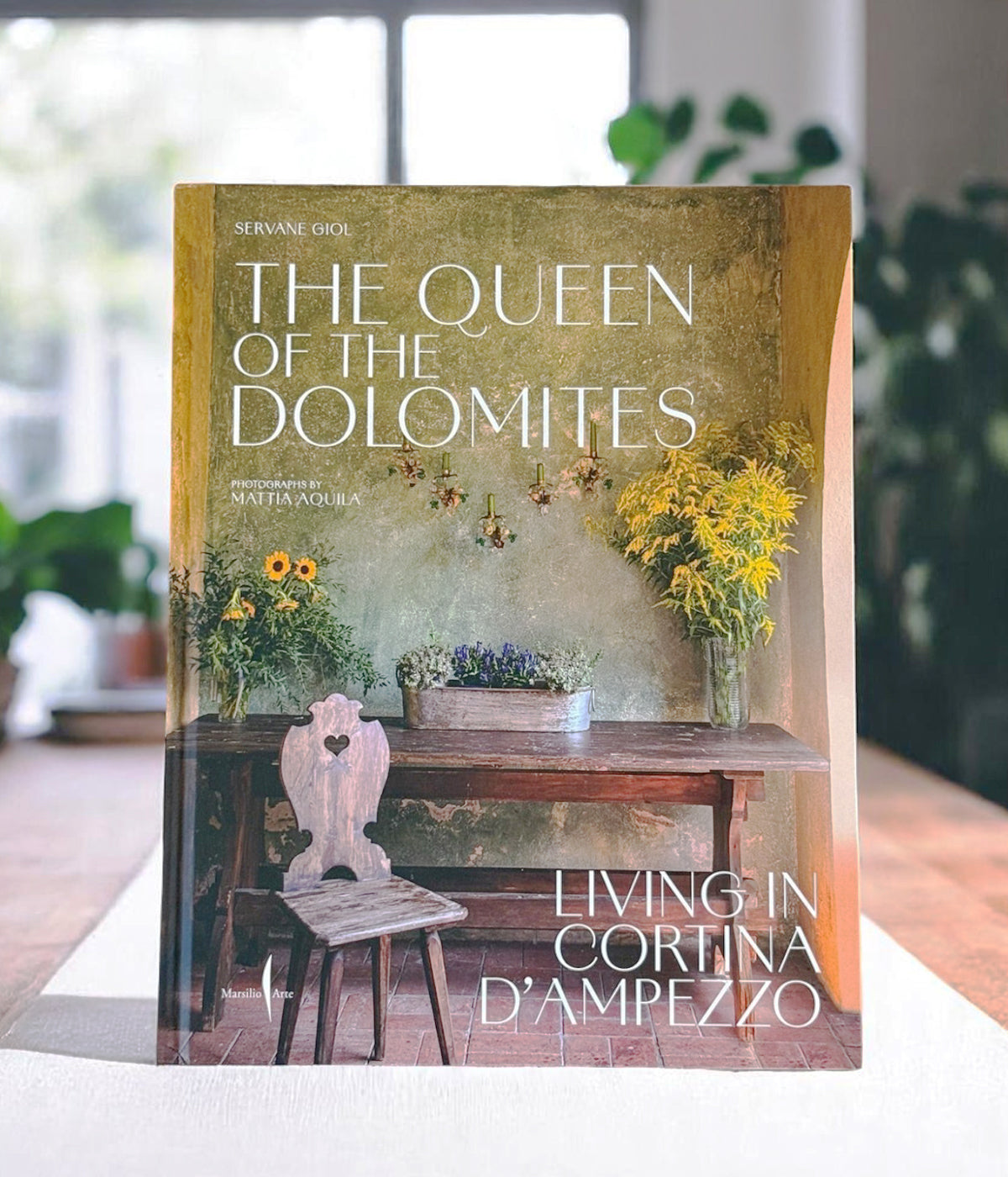 Italian home design coffee table book showing showing floral-painted walls and rustic furniture