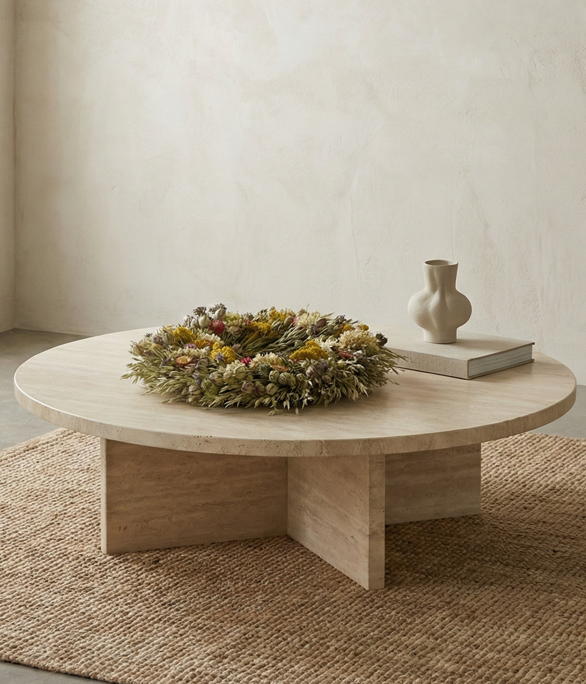 Linden wreath displayed flat as table centerpiece on round wood table with neutral vase