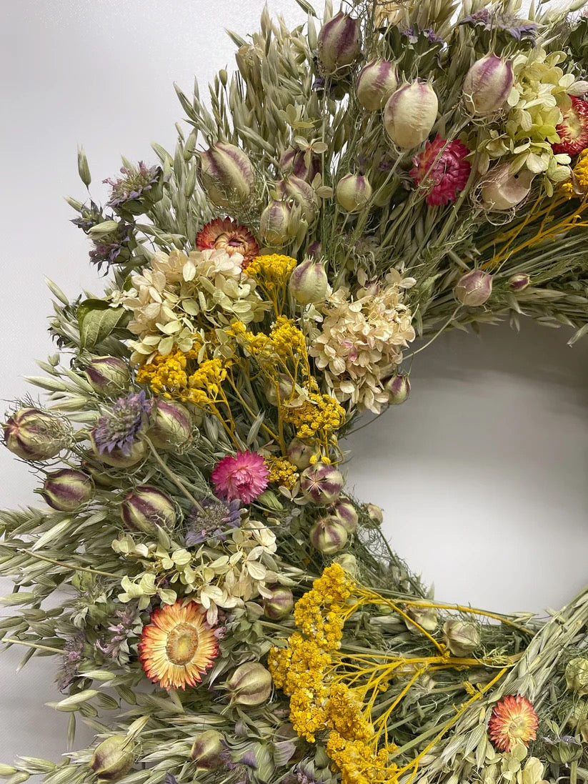 Close-up of Linden wreath showing yellow yarrow, pink strawflowers, and pale green hydrangea
