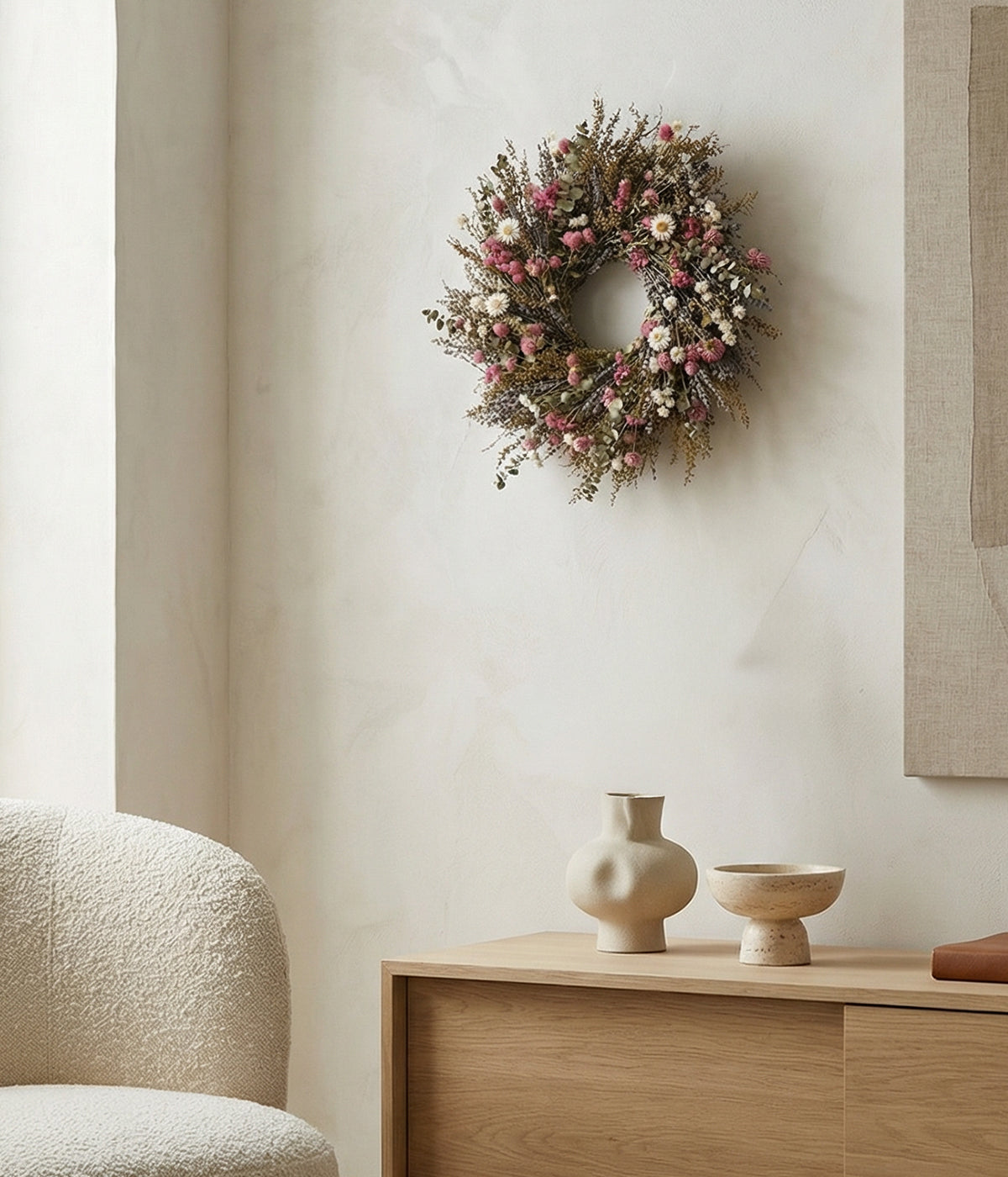 Camille pink wreath displayed on neutral wall above wooden console with decor