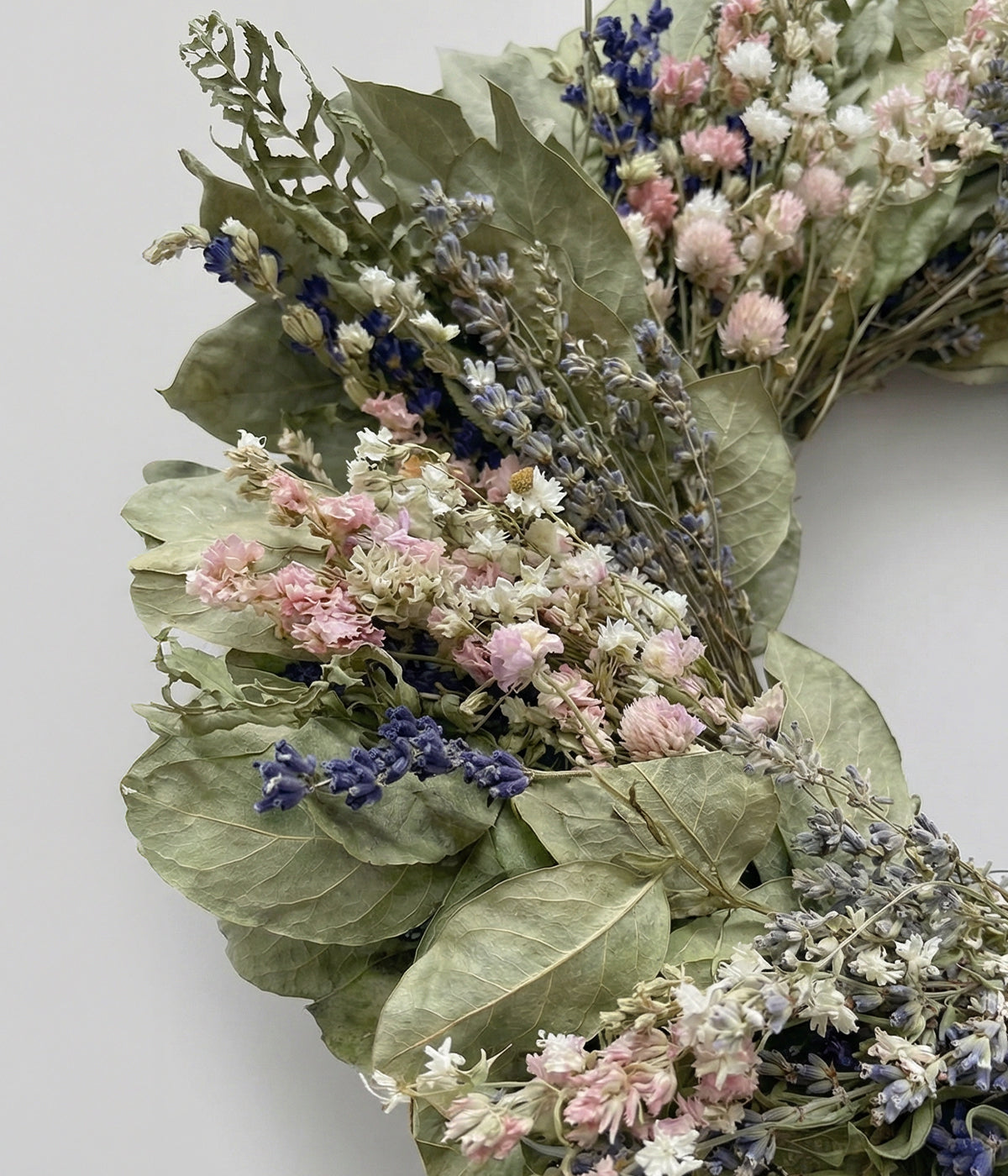 Close-up of dried wreath with salal leaves, lavender, larkspur, and ammobium flowers