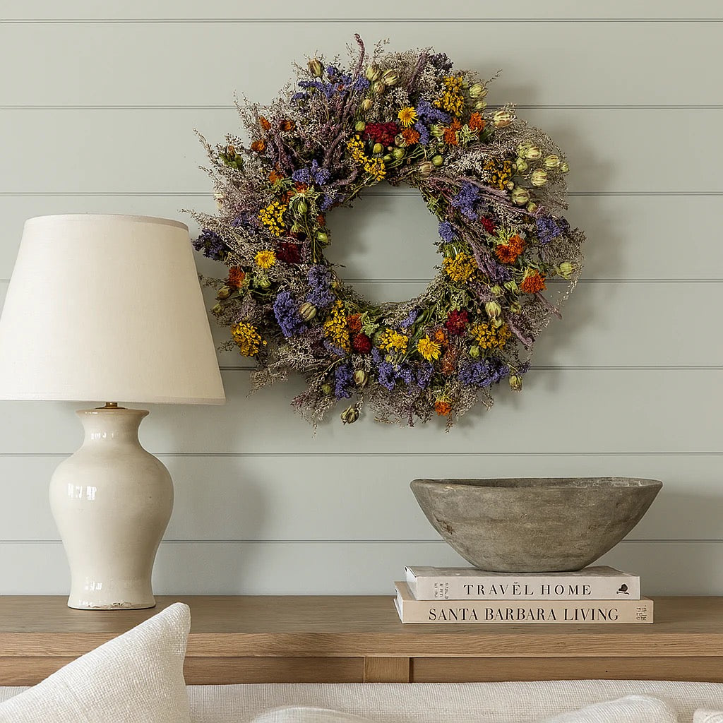 Estelle wreath displayed on shiplap wall above wooden console with lamp and ceramic bowl