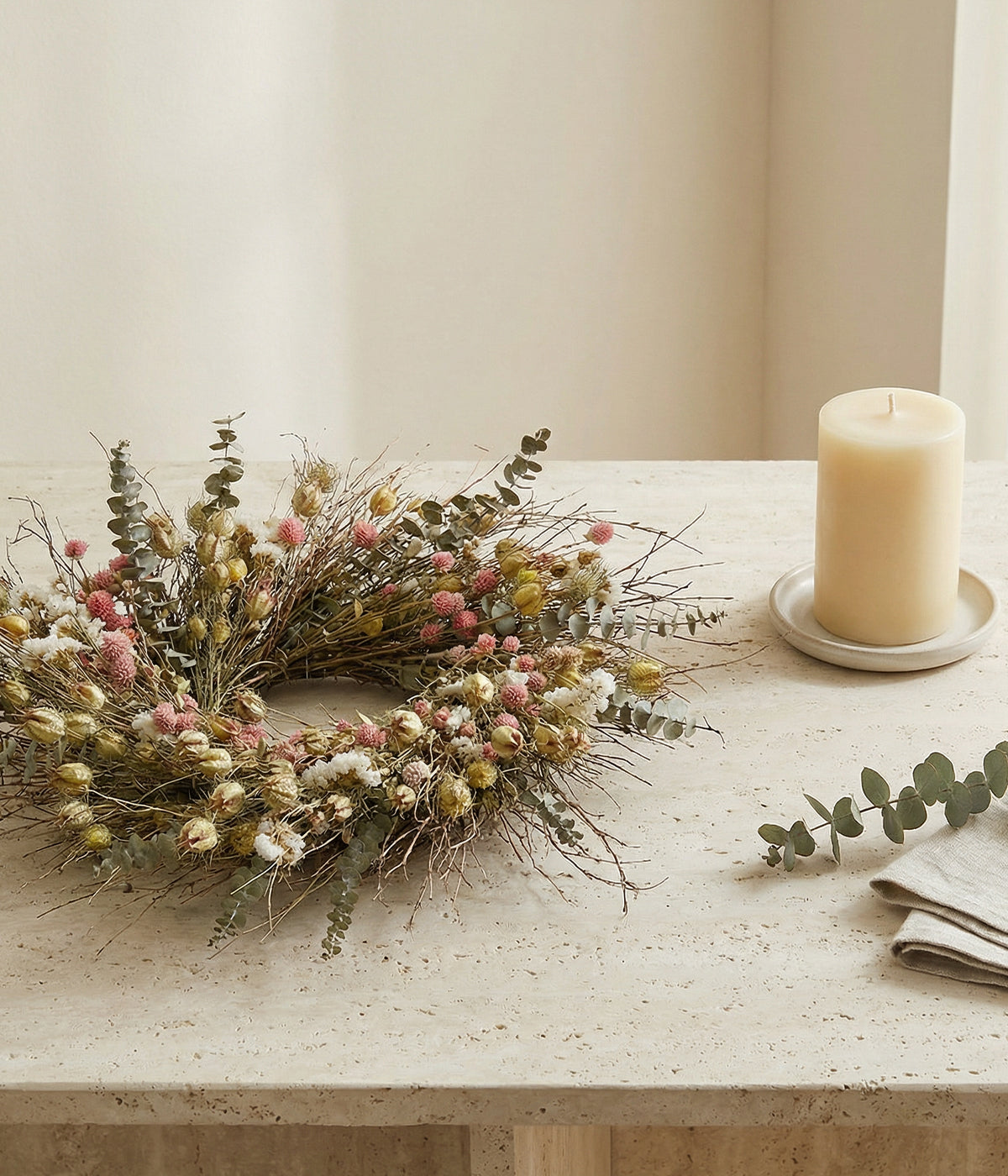 Pink floral wreath displayed flat as table centerpiece with candle in center