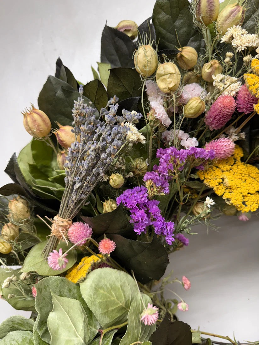 Close-up wreath with preserved salal leaves, dried lavender bundles, yellow yarrow, and pink statice