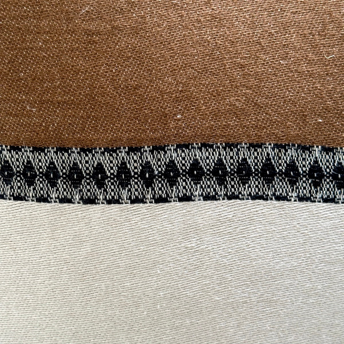 Close view of Etienne pillow showing natural weave and hand-dyed stripe accent