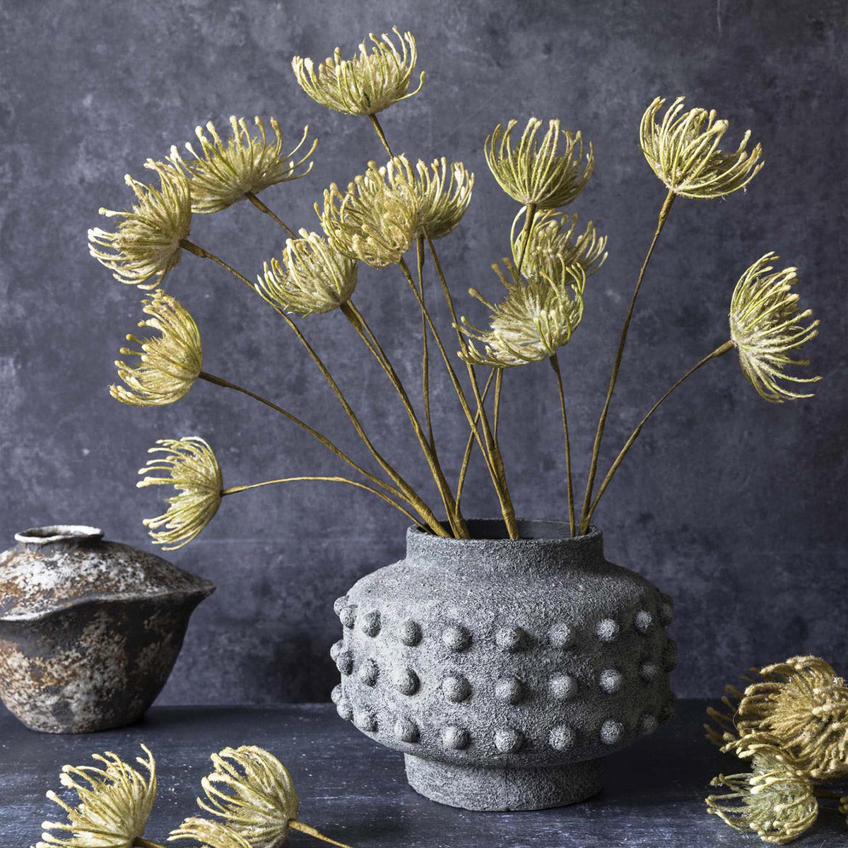 Artificial pincushion protea in a medium sized stone vase for organic arrangements