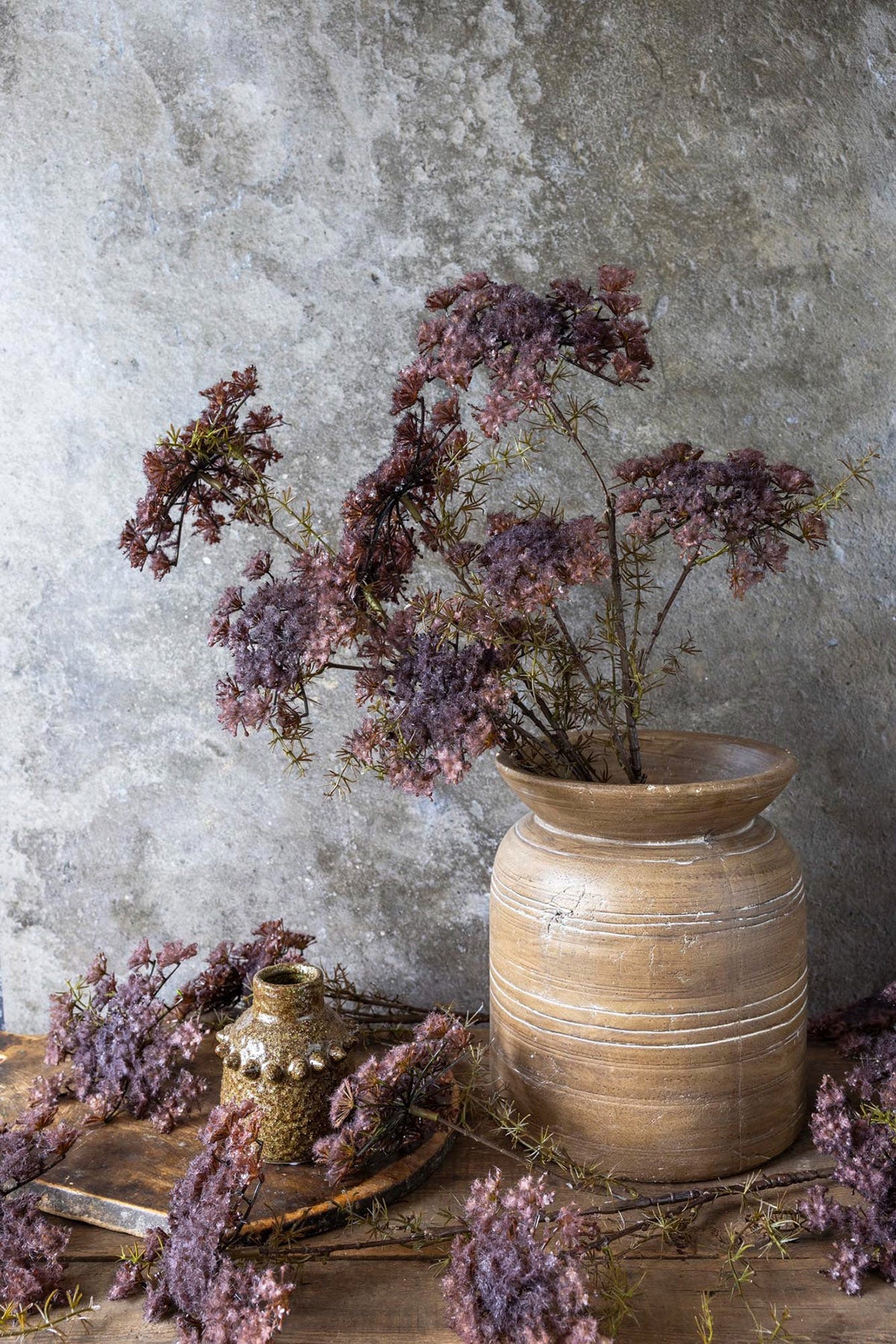 Purple artificial wildflower stem styled in a tall vessel for delicate floral arrangements