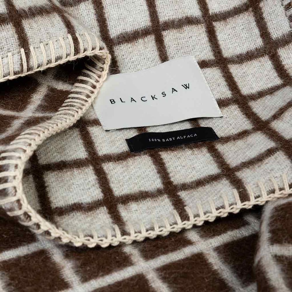 Floyd reversible throw showing ivory and coffee faces at folded corner