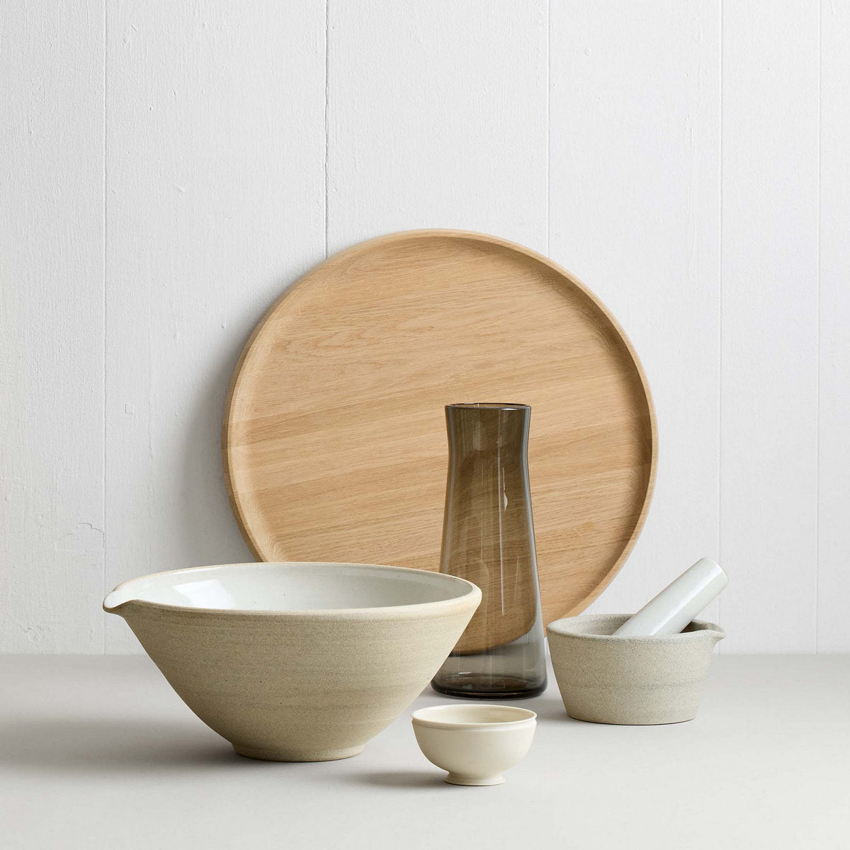 Stoneware mortar and pestle set styled on kitchen counter with other kitchen bowls