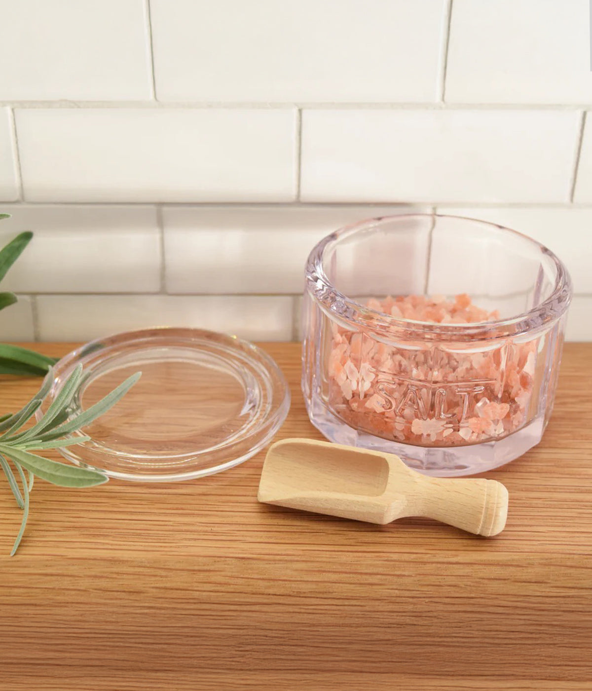 Minimalist and small glass salt container with wooden scoop for cooking and serving