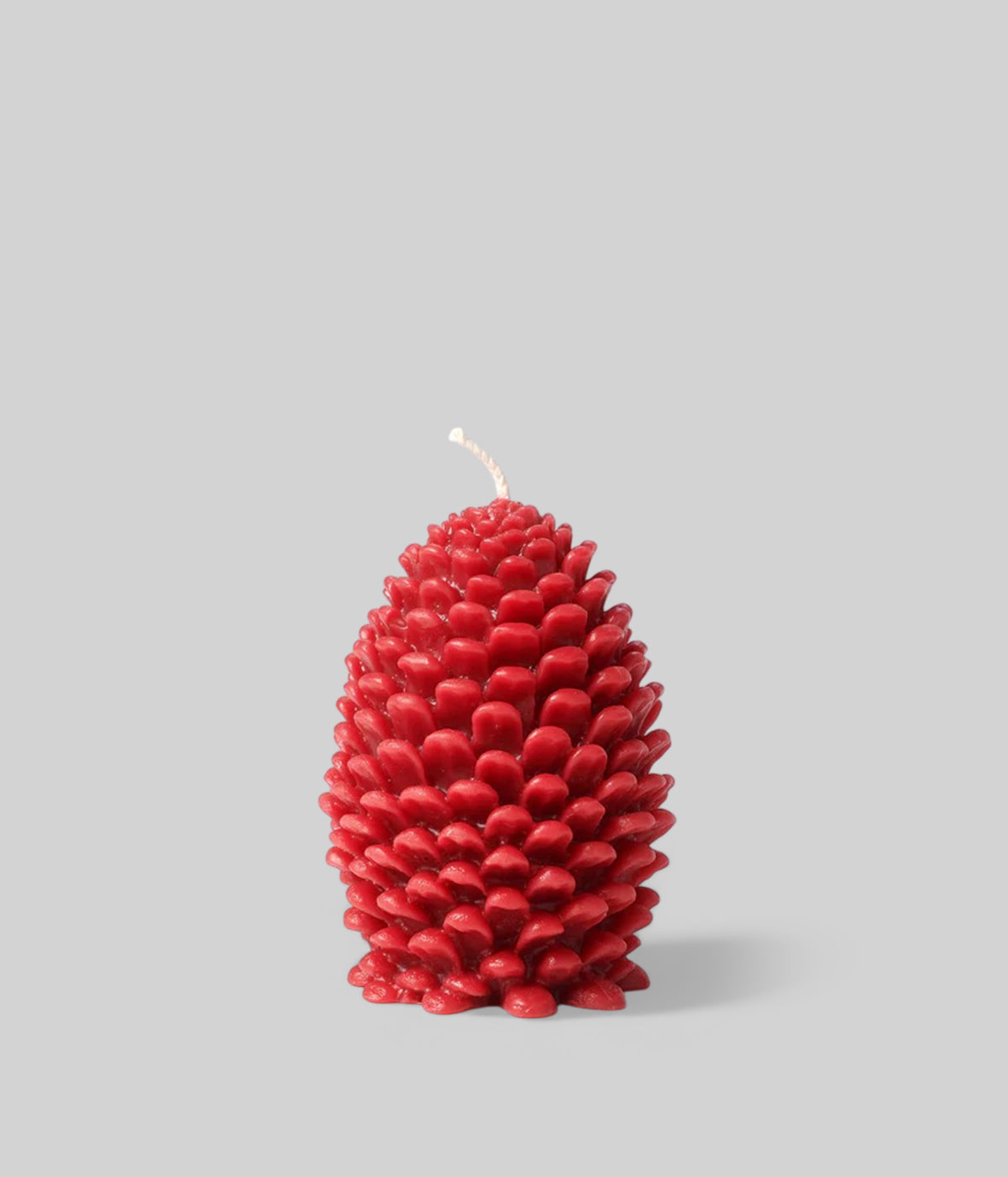 Bittersweet red jumbo cone candle glowing with hollowing petal pattern