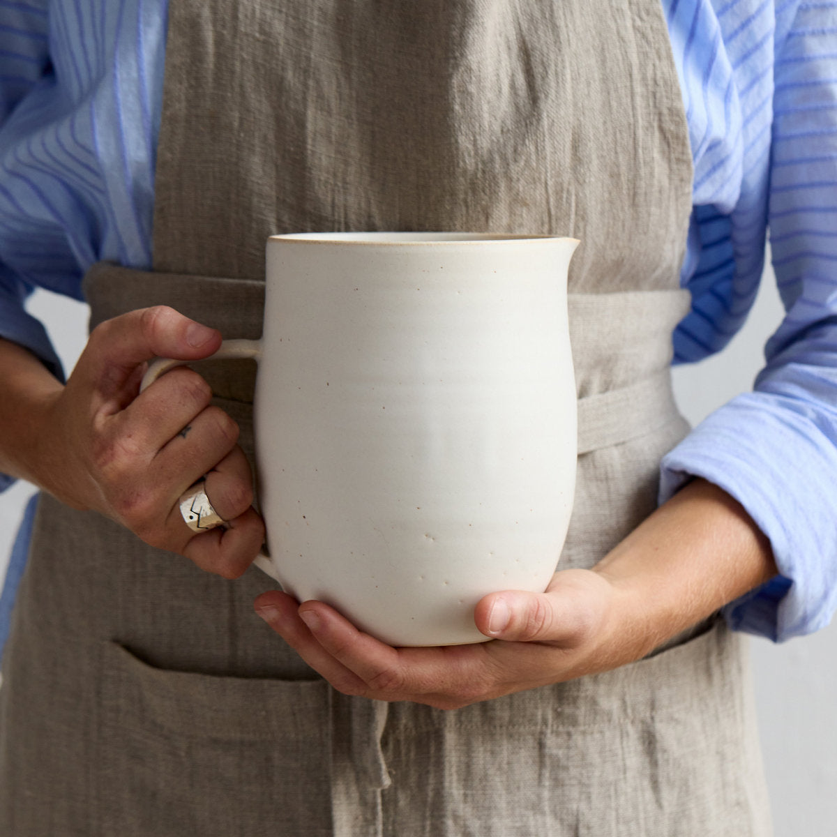 Hand-thrown stoneware pitcher vase in white glaze with rounded body and wide opening