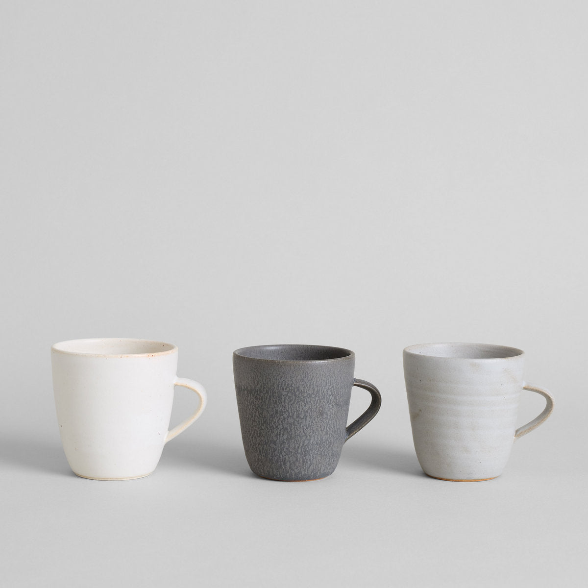 Wheel-thrown ceramic mugs with natural variation from kiln firing