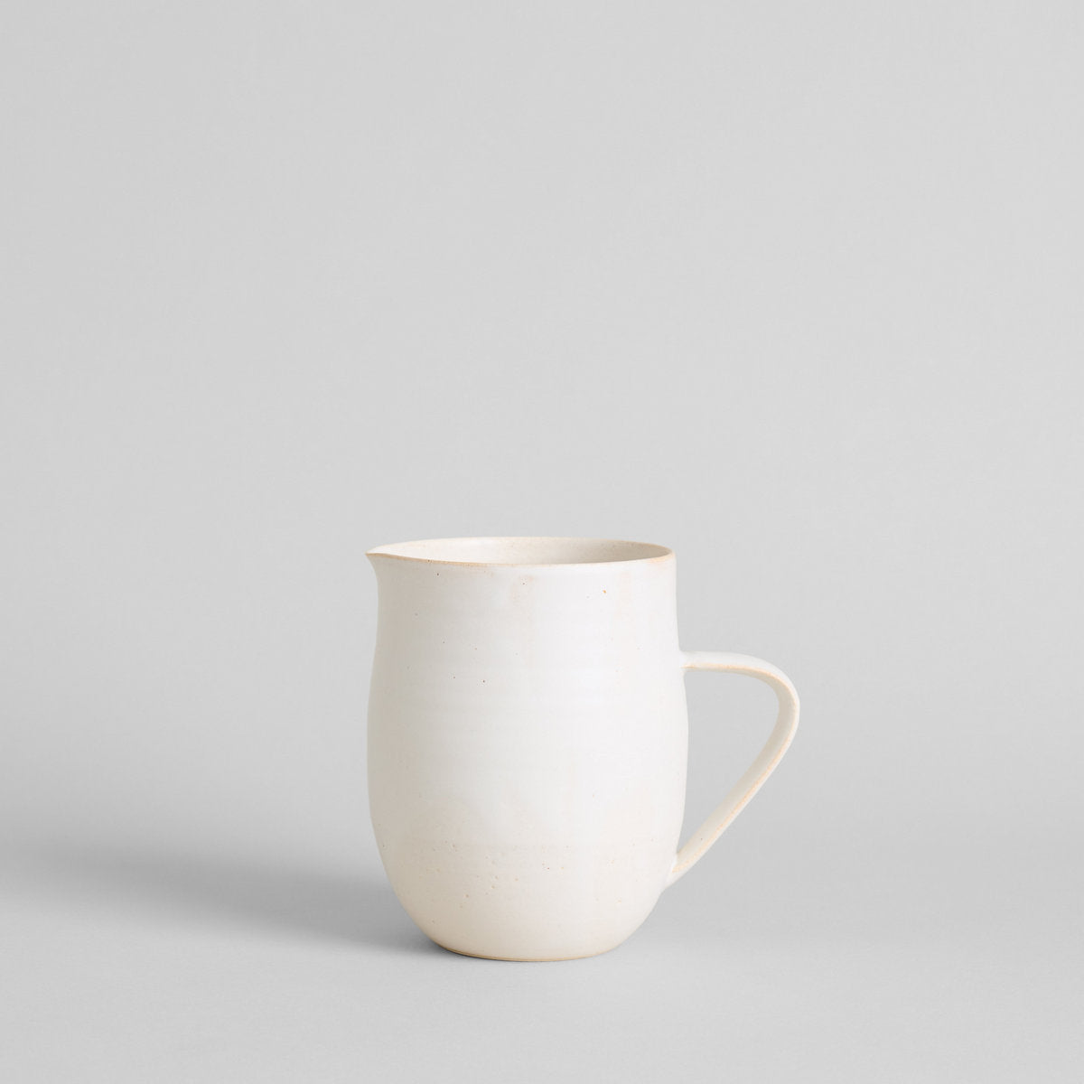 White farmhouse pitcher vase in stoneware with classic white glaze and curved handle