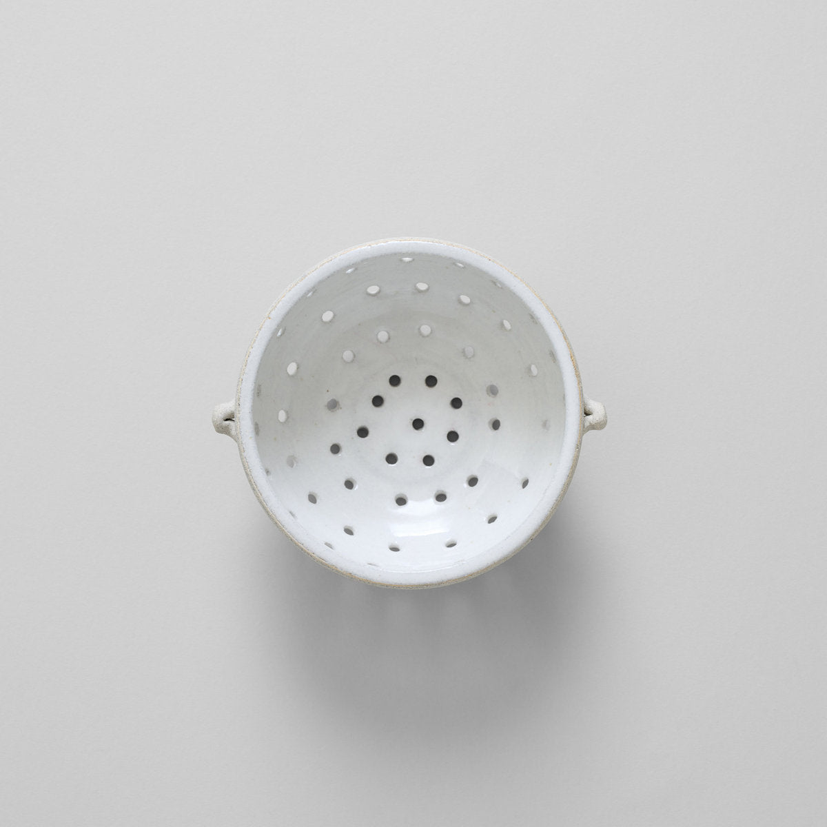 Stoneware berry colander with speckled clay exterior and smooth glazed interior