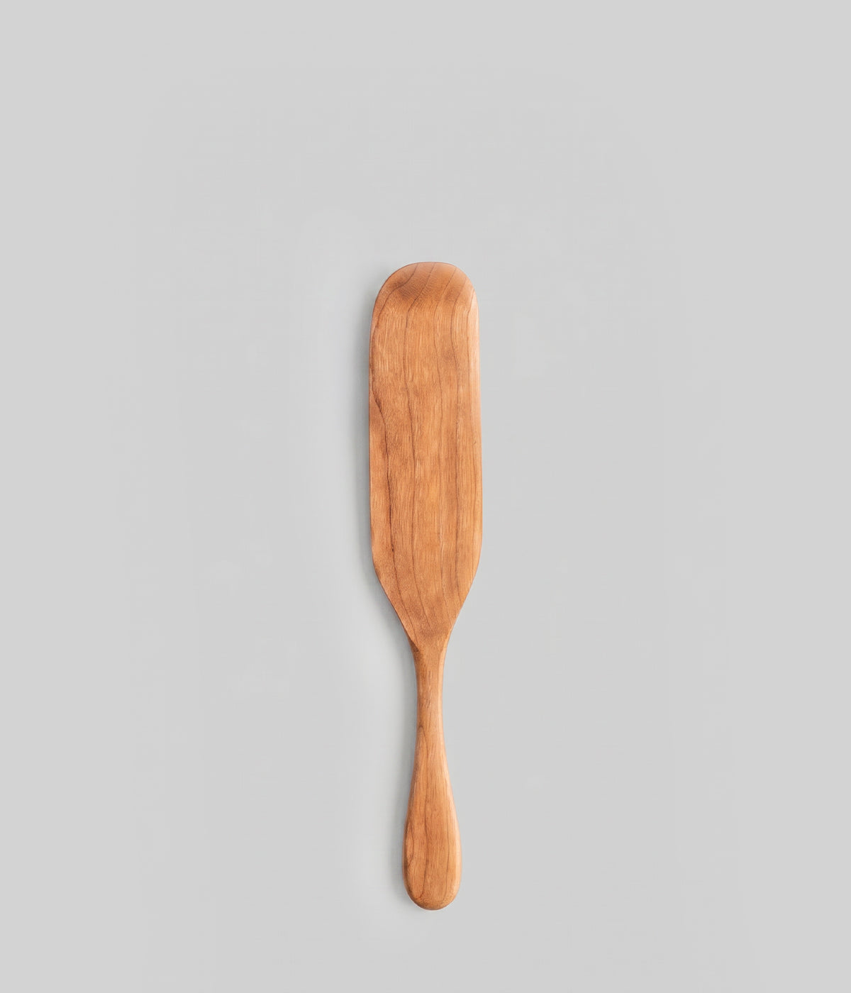 12" handmade large wooden spurtle on a gray background