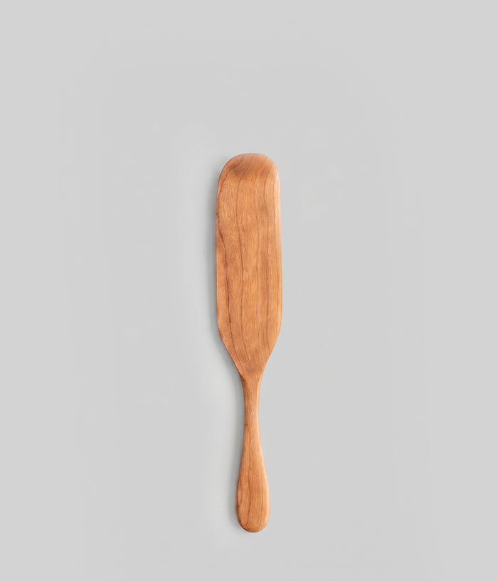 12" handmade large wooden spurtle on a gray background