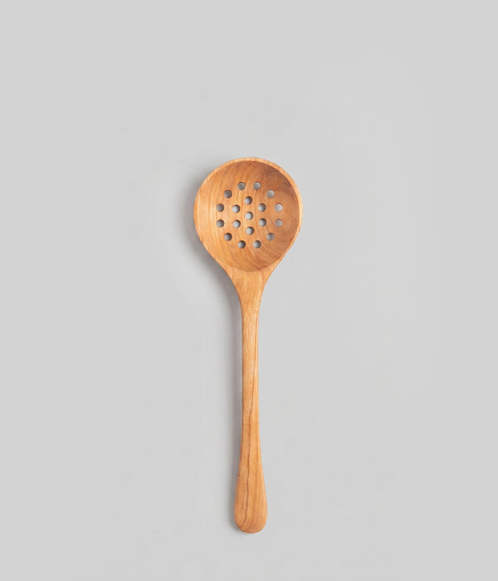 12" handmade wooden strainer spoon with a perforated design on a gray background