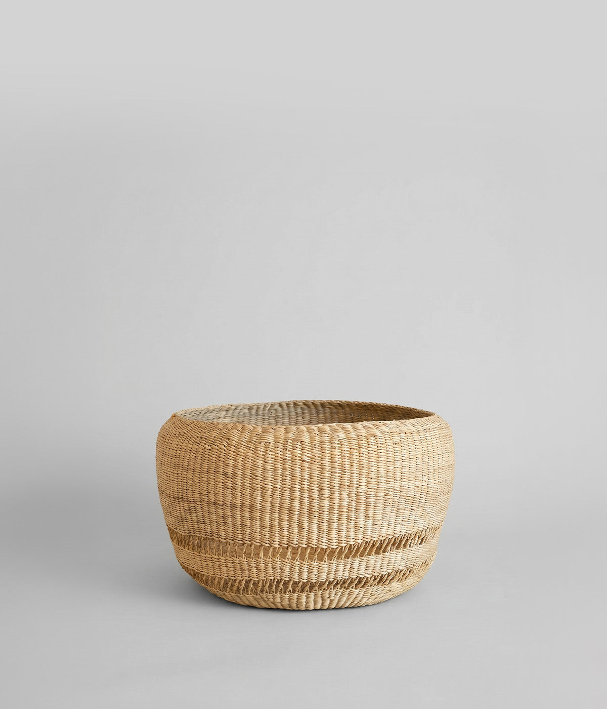 Round woven planter made from elephant grass with mixed weave pattern