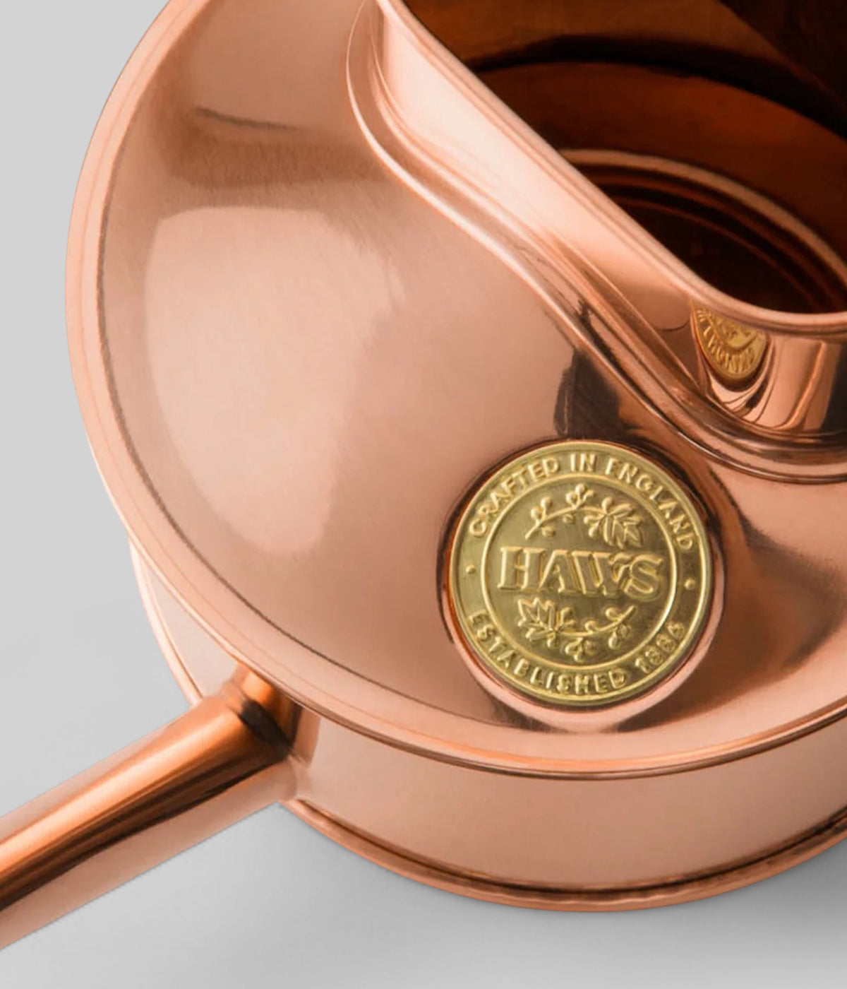 One pint copper watering can with curved spout and polished mirror finish design