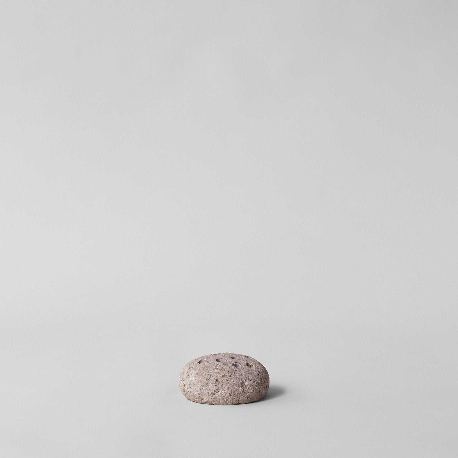 Single river-worn stone flower frog with carefully drilled holes