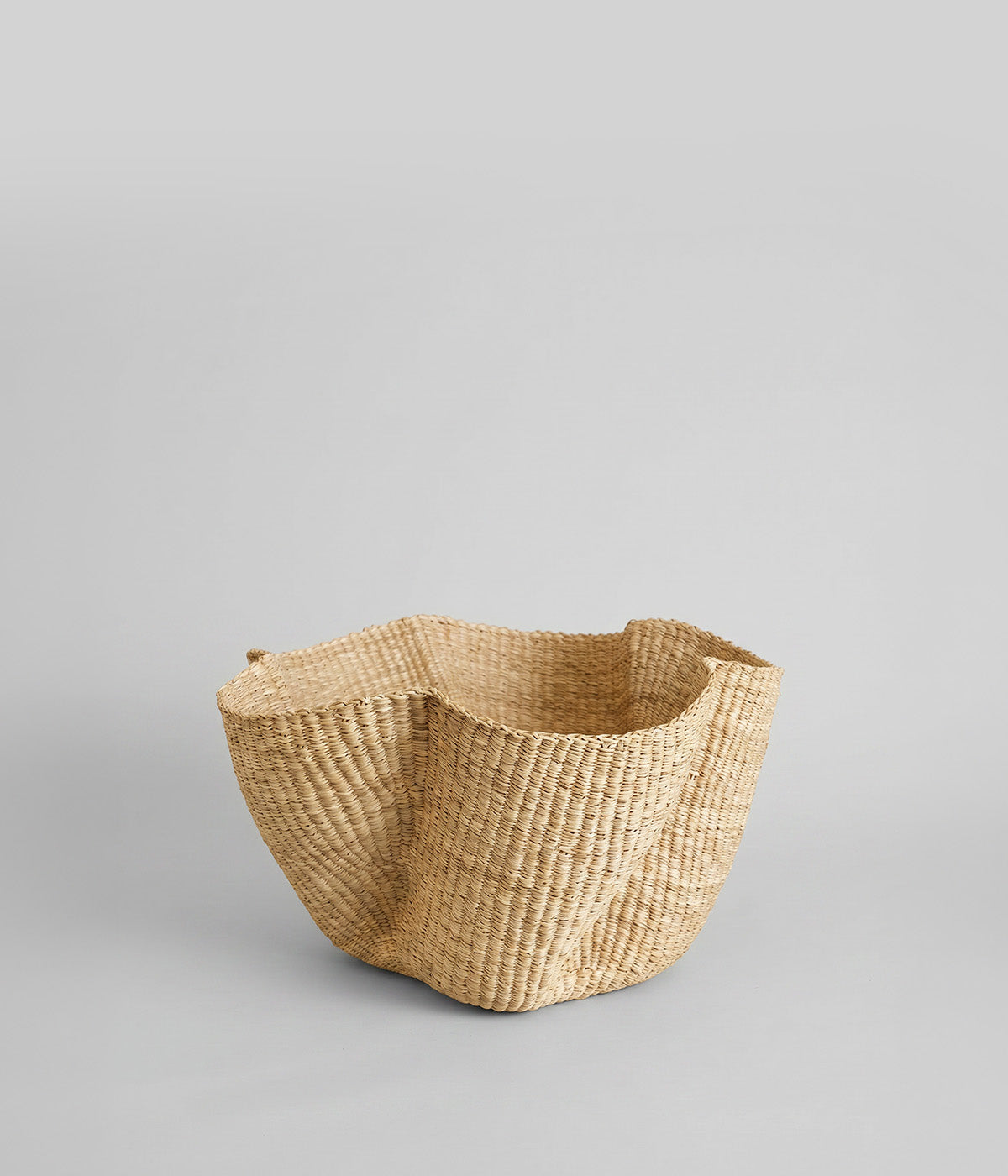 Hand-woven natural wave basket made from elephant grass with sculptural petal rim