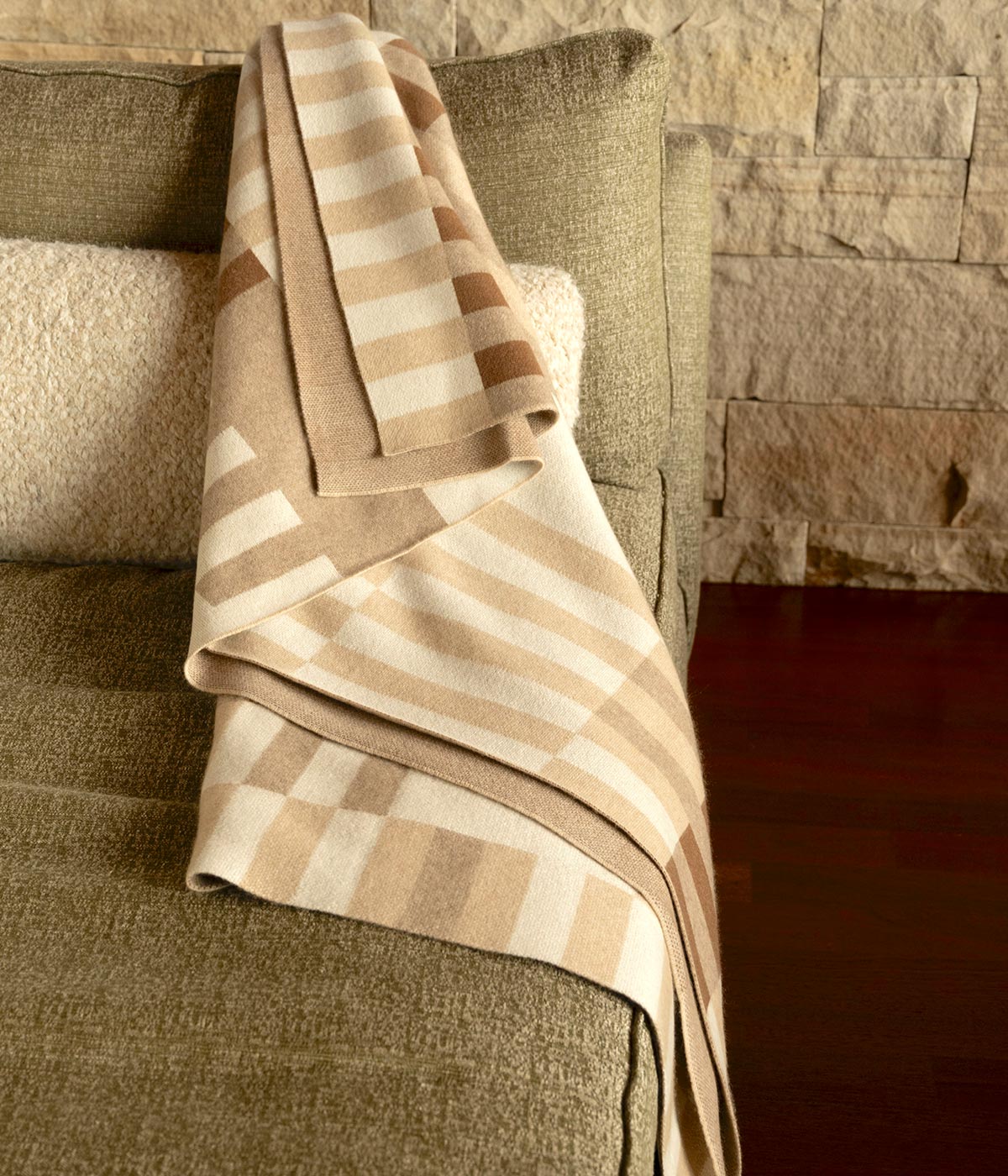 Cognac cashmere throw draped over a sofa, adding warmth and texture to home decor