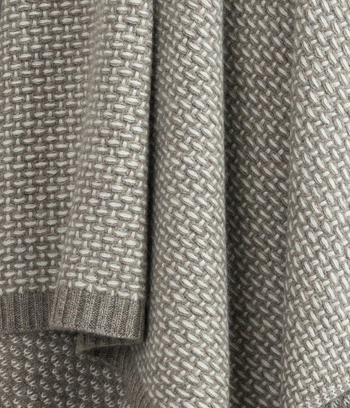 Close up of white cashmere and platinum yak fibers showcasing the fine weave and luxurious softness