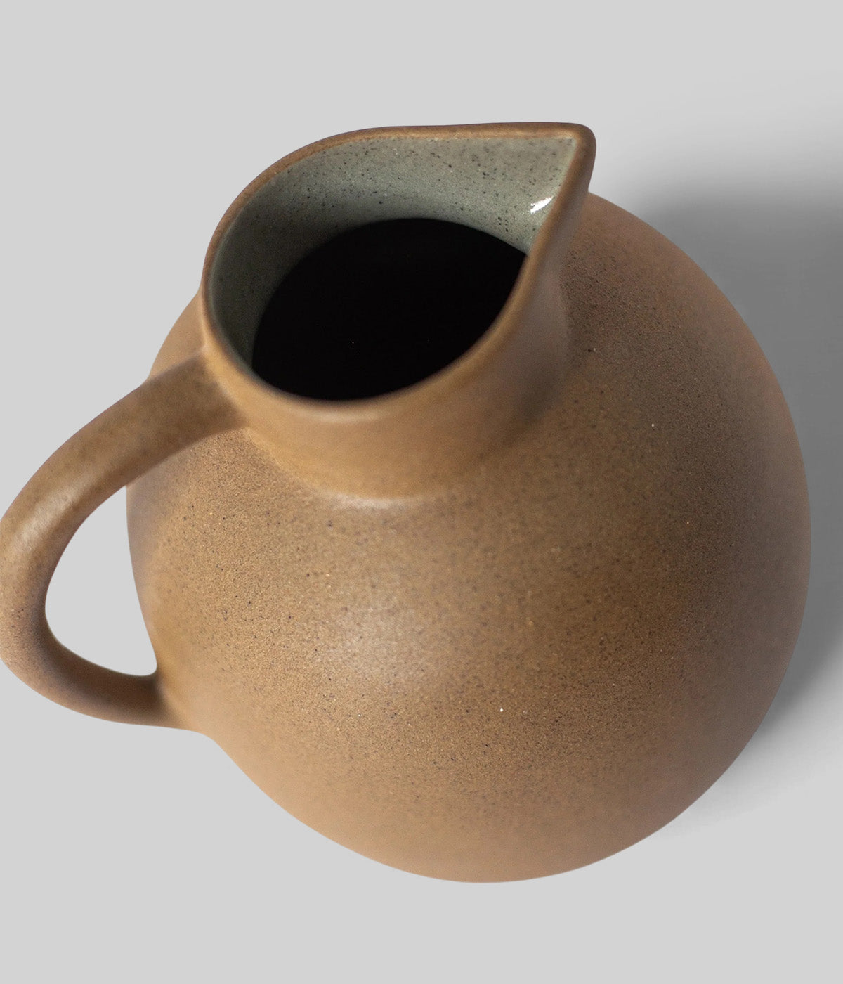 ceramic pitcher with rounded silhouette and smooth glazed interior