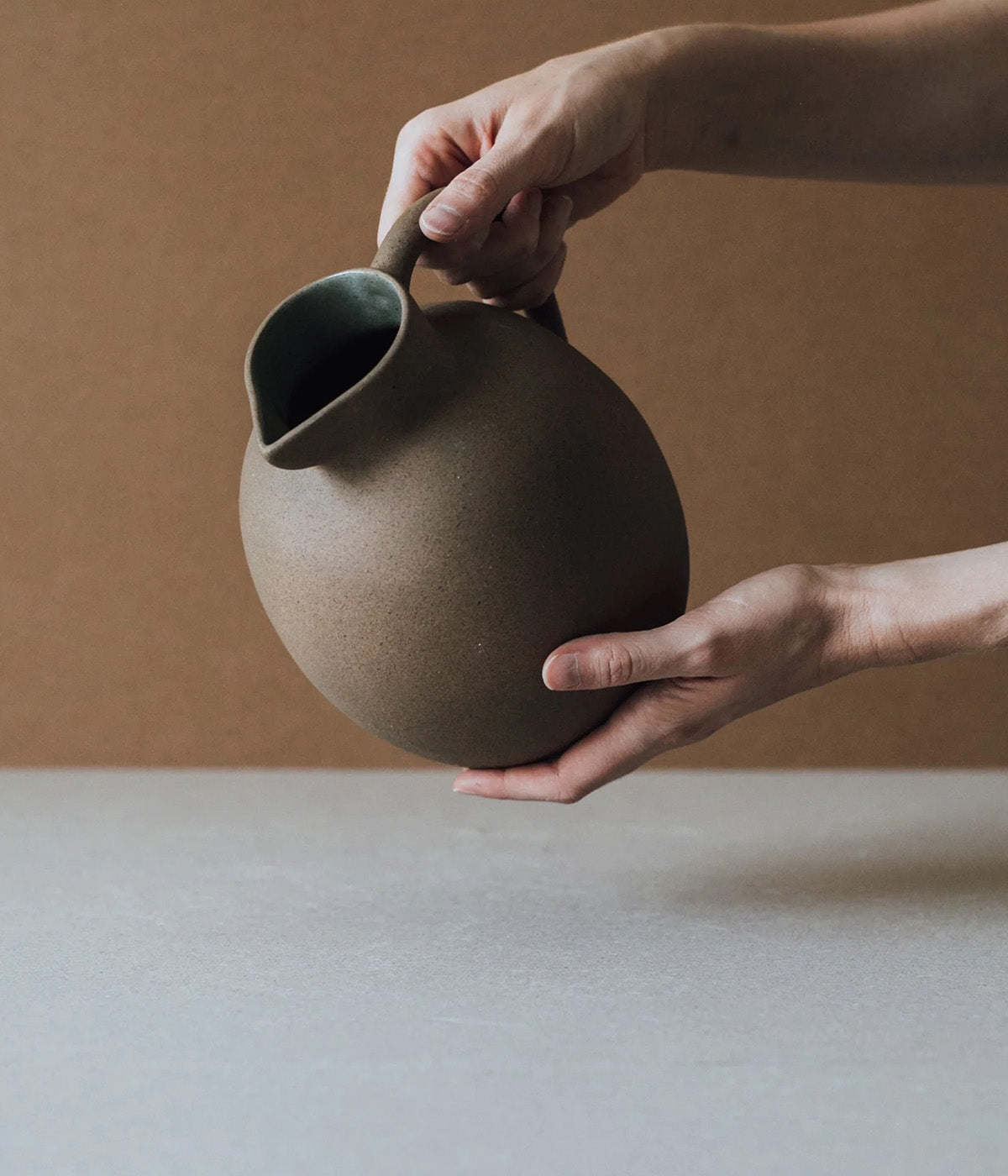 large round ceramic vase with unglazed exterior and soft earthy tones from Mexico