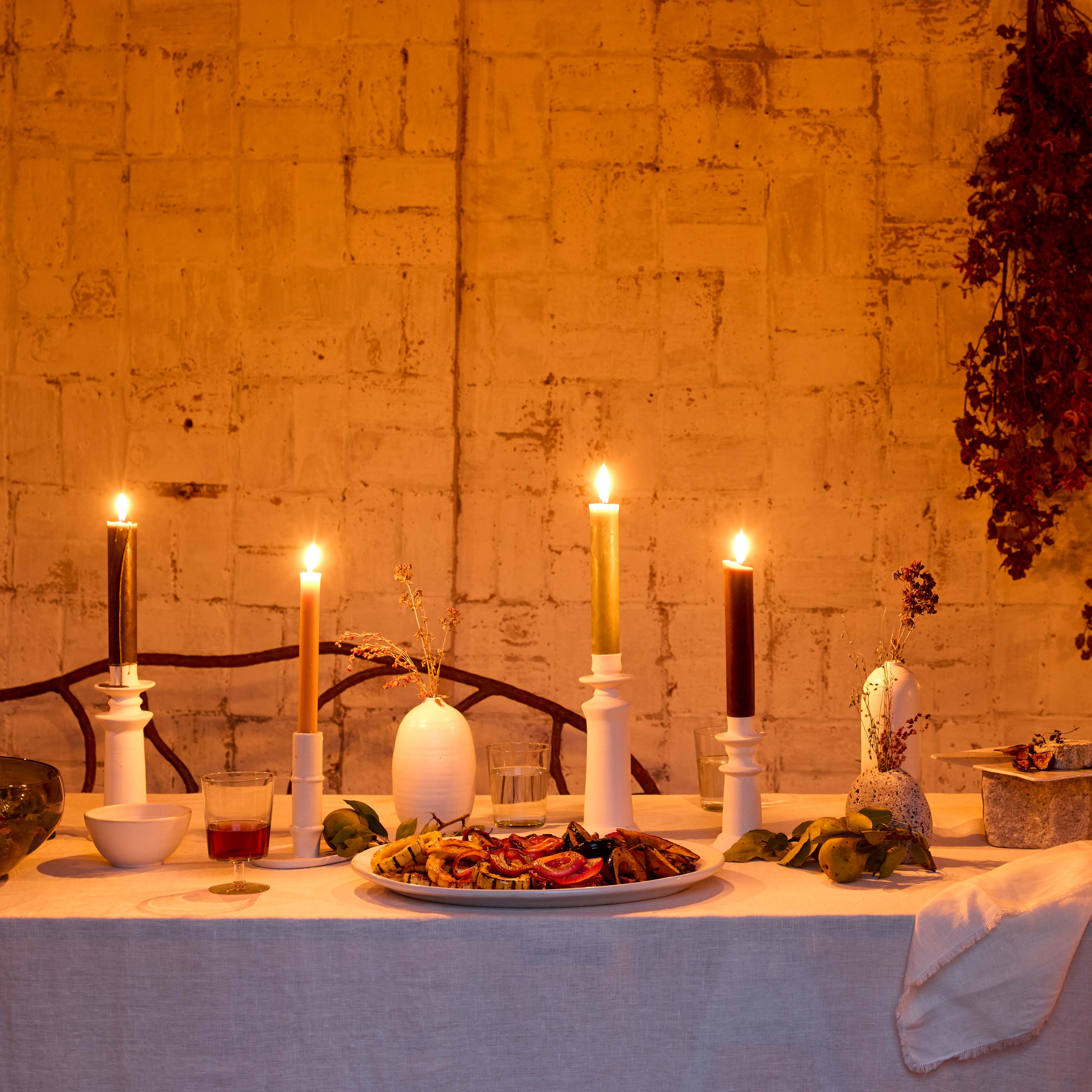 White ceramic taper candle holder on a tabletop display