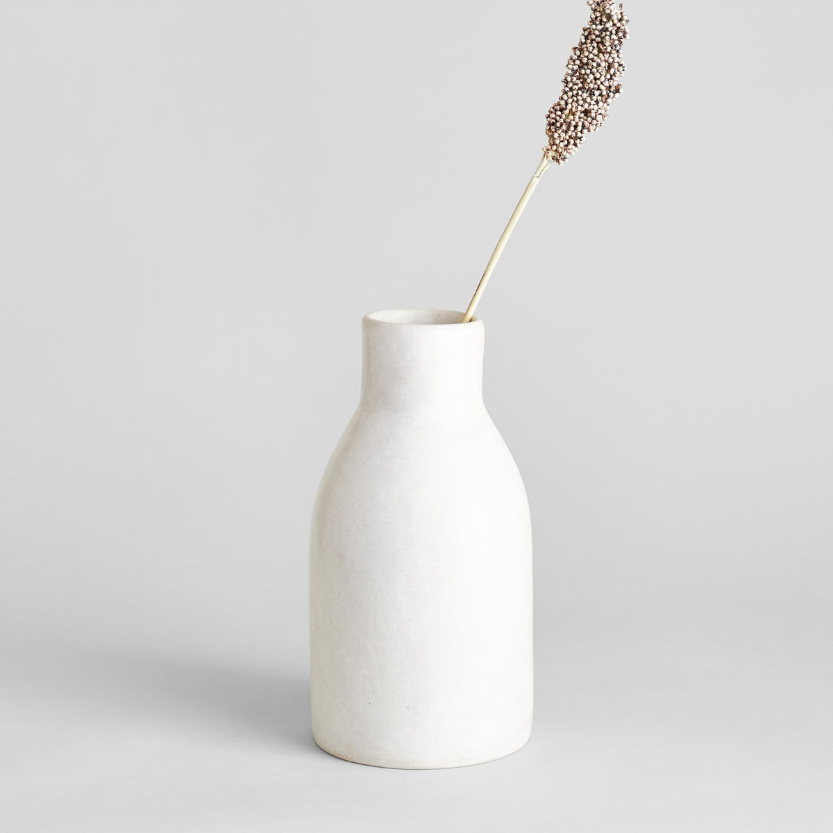 Ivory Moroccan clay vase styled with dried stems
